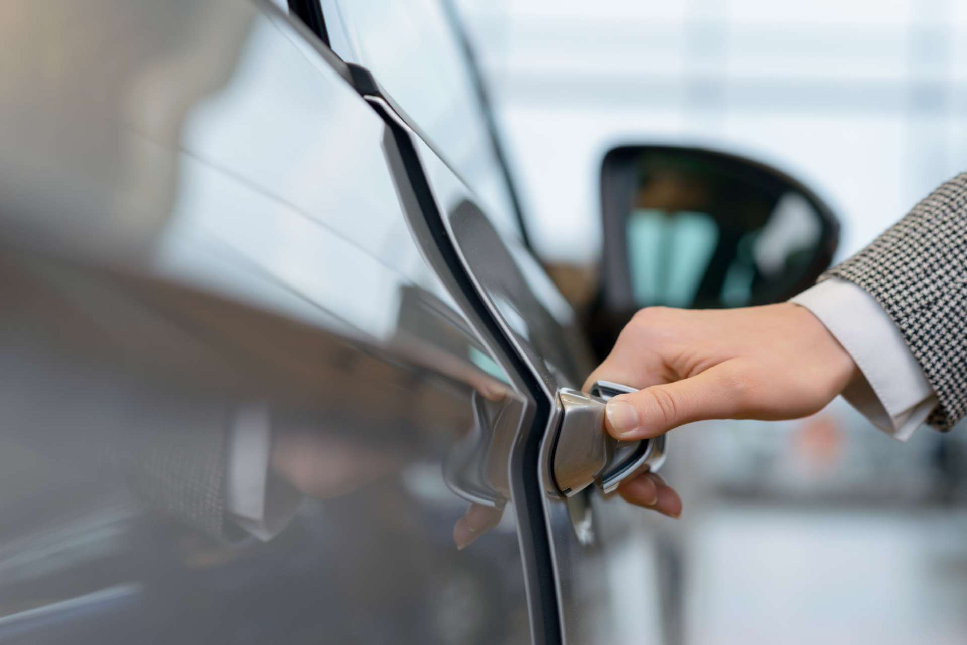 Car dealer opening grey car door