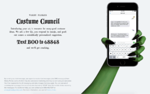 Warby Parker Halloween campaign ad; green hand clutches phone with messages; ad text says 'Costume Council, Text BOO to 68848' 