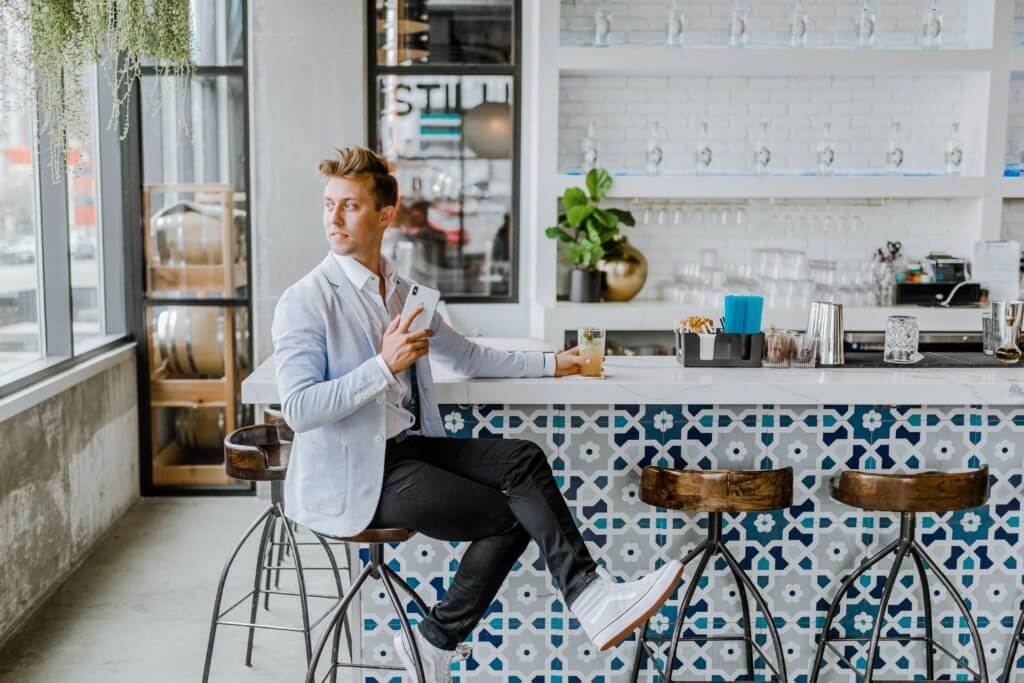 Young person in restaurant with with phone.