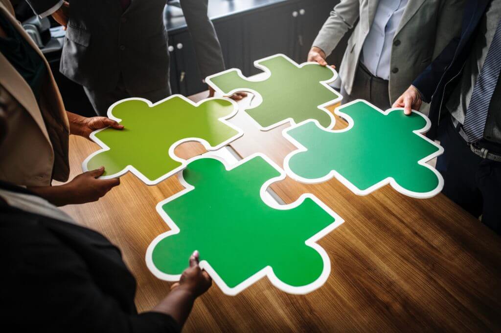 Business people with puzzle pieces to symbolize SMS integrations