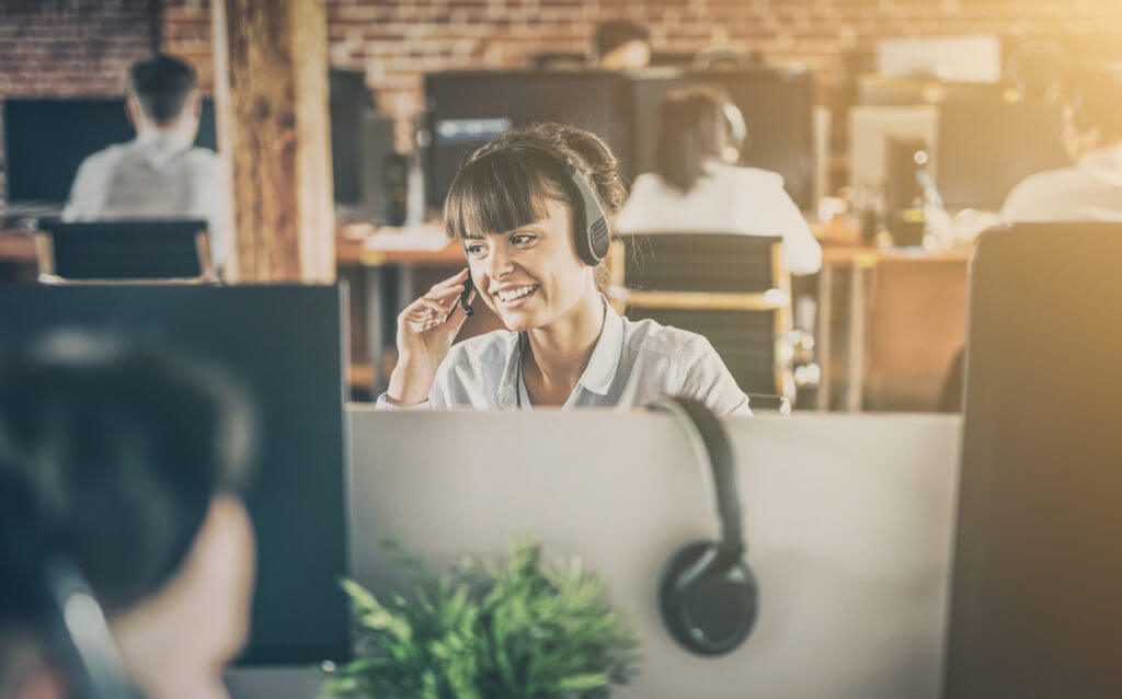 Omnichannel agent on phone at computer.