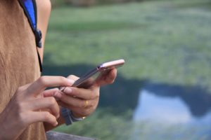 Person reading and typing on phone.