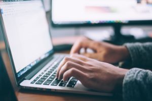 Agent typing on laptop keyboard.