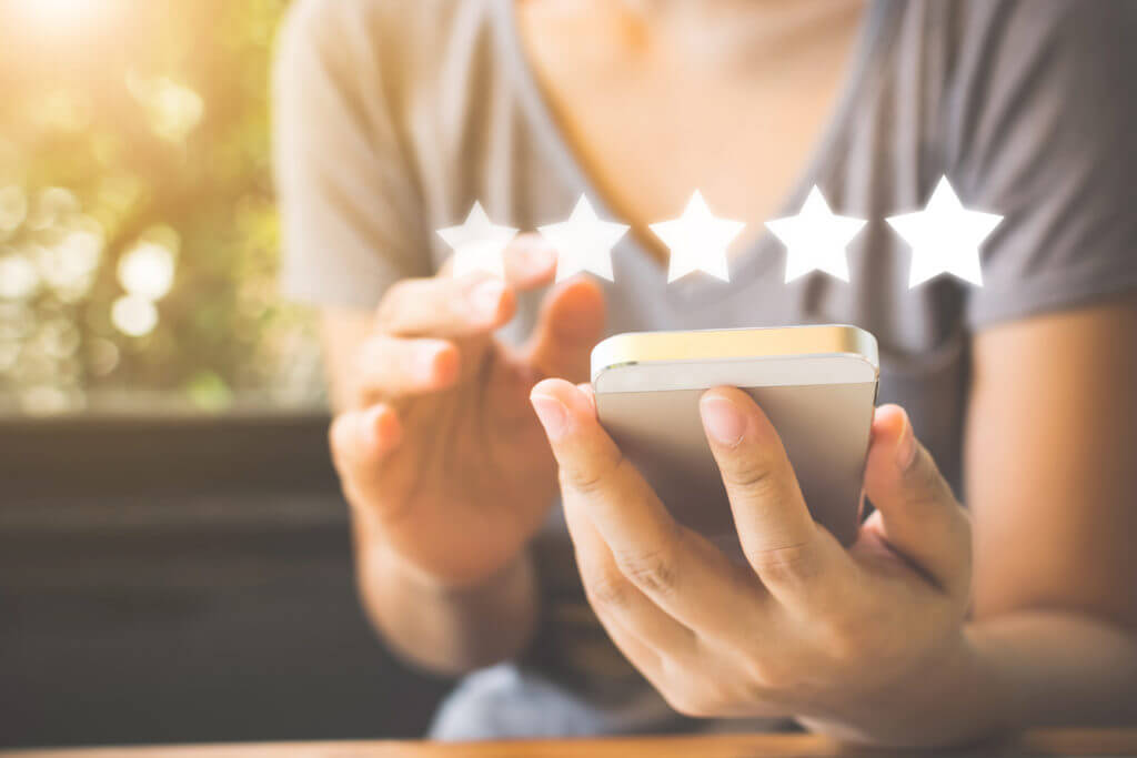 Person writing SMS review on phone