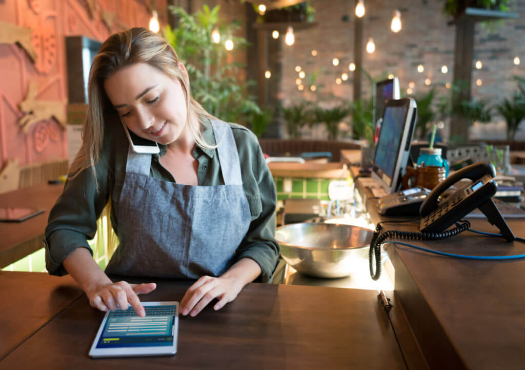 Women coordinating delivery over phone and tablet.