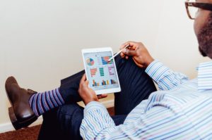 Businessman reviewing reports on tablet.