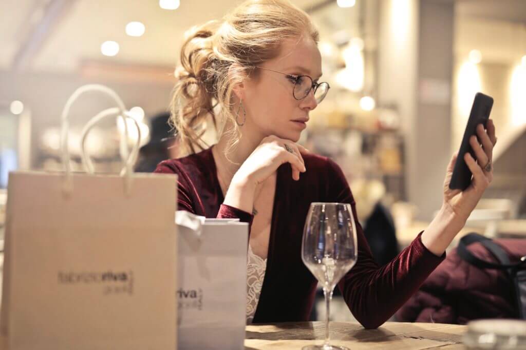 Woman who is looking at phone while shopping