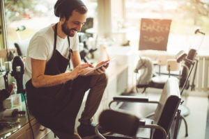 Barber reading SMS on phone.