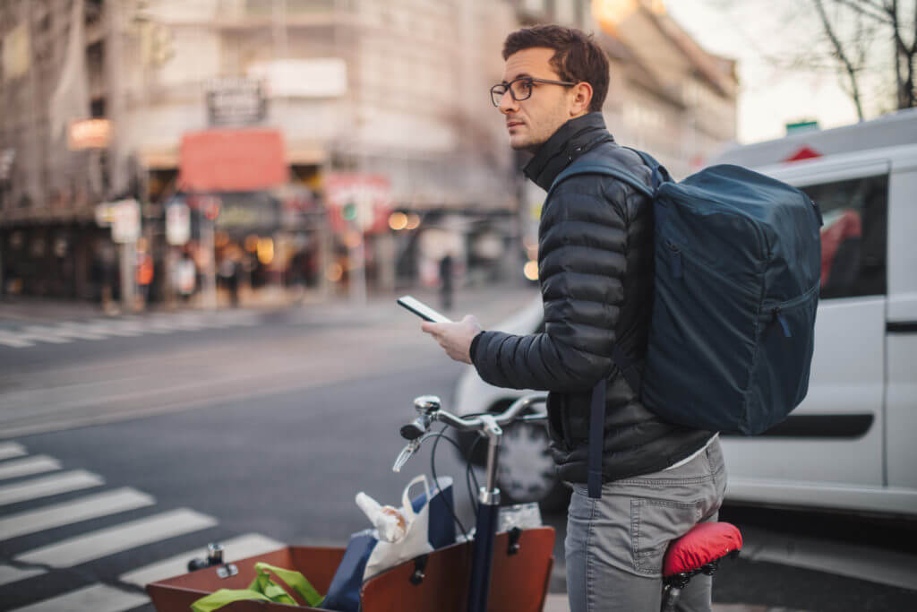 Delivery person texting with phone.