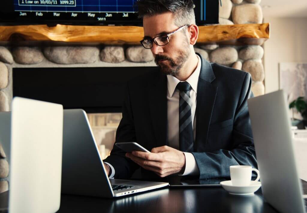Salesperson in suit at desk texting SMS leads