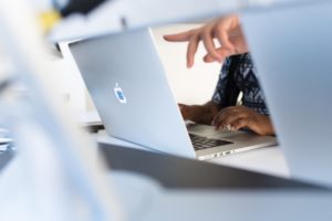 Business person pointing at computer screen.