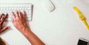 Person working at desk with computer.