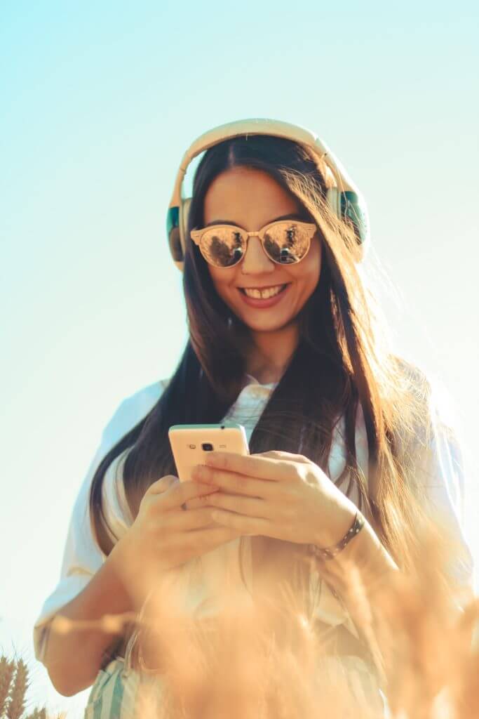 Woman in sunglasses checking phone.