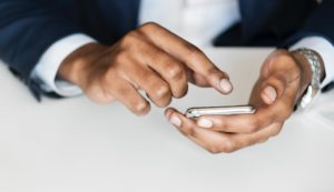 Businessman holding phone and texting.