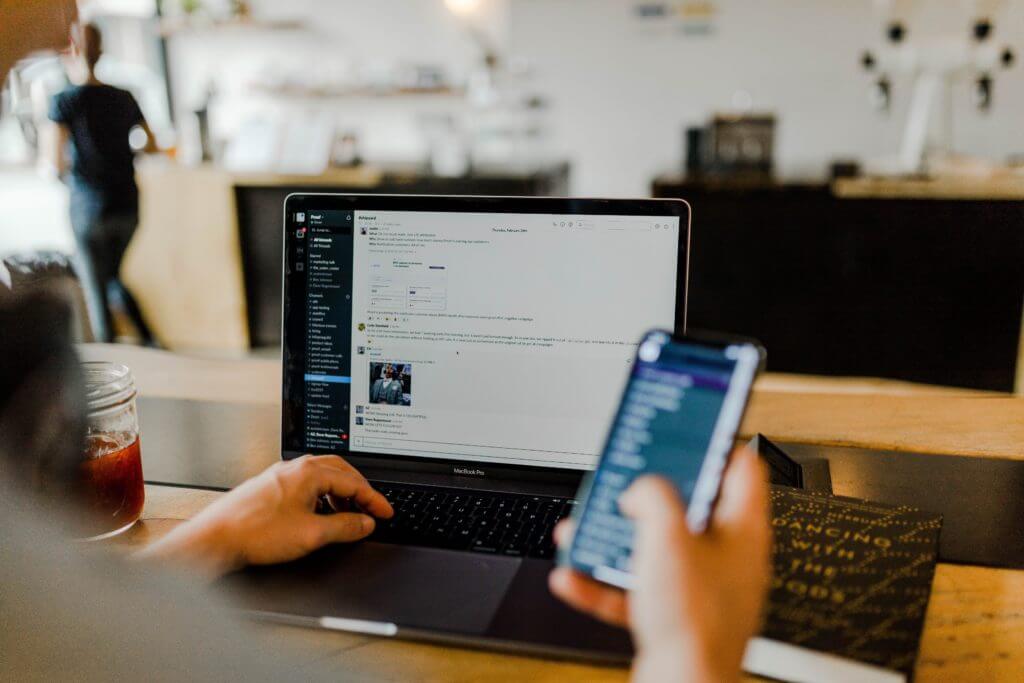 Person working with laptop and phone.