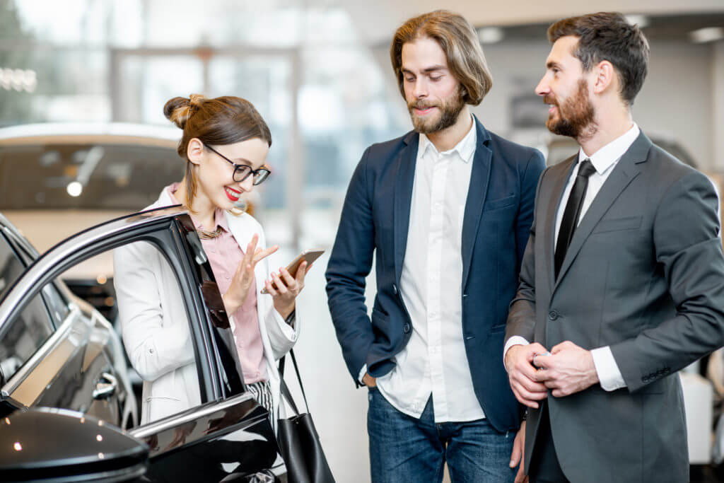 Automotive salesperson speaking with customers