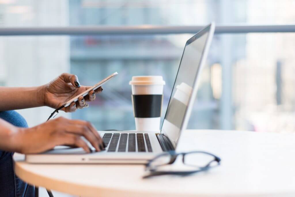 Business person using phone and computer