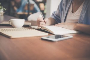 Student writing at desk