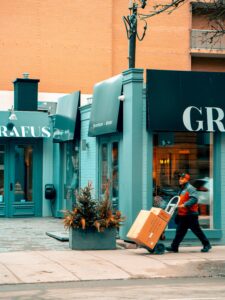 man pushing handtruck, having used business text messaging to arrange delivery