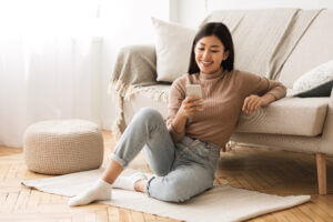 Woman receiving a personalized SMS template text while sitting on the floor