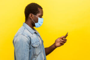 Side view of man using a business texting solution during COVID-19