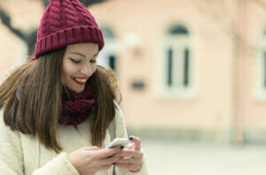 Young woman replying to a holiday SMS customer engagement text