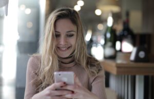 Customer in cafe smiling at business text message