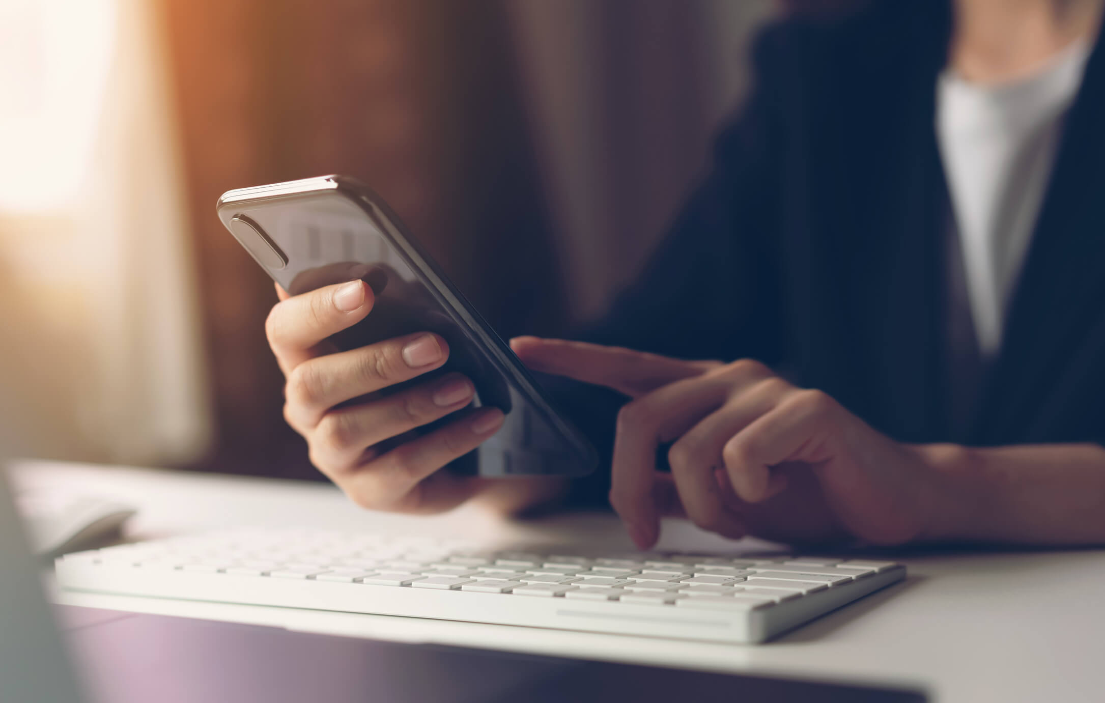 Student's hand reaching out to tap open a college SMS message