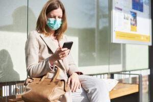 Woman Using Business SMS During COVID-19 Mask Requirements