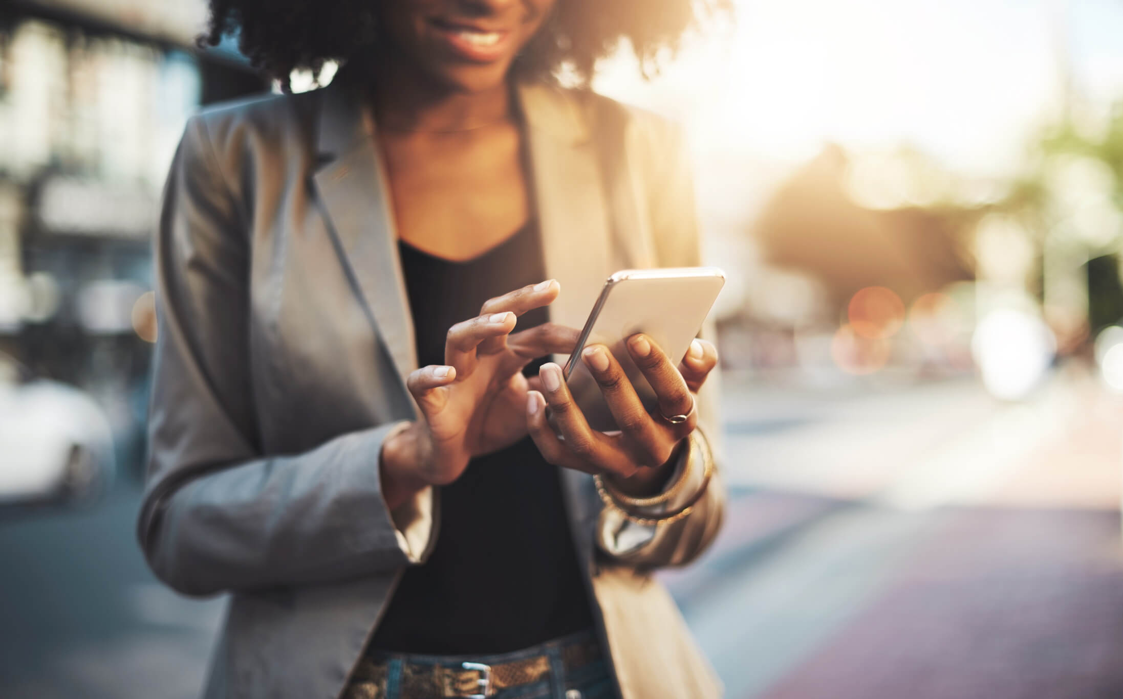 Black insurance SMS agent checking incoming client messages on her phone