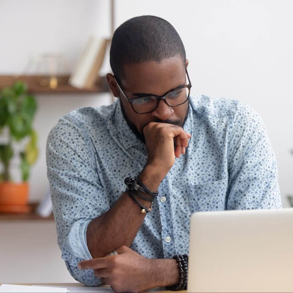 Man at laptop using business text messaging to solve customer issues.