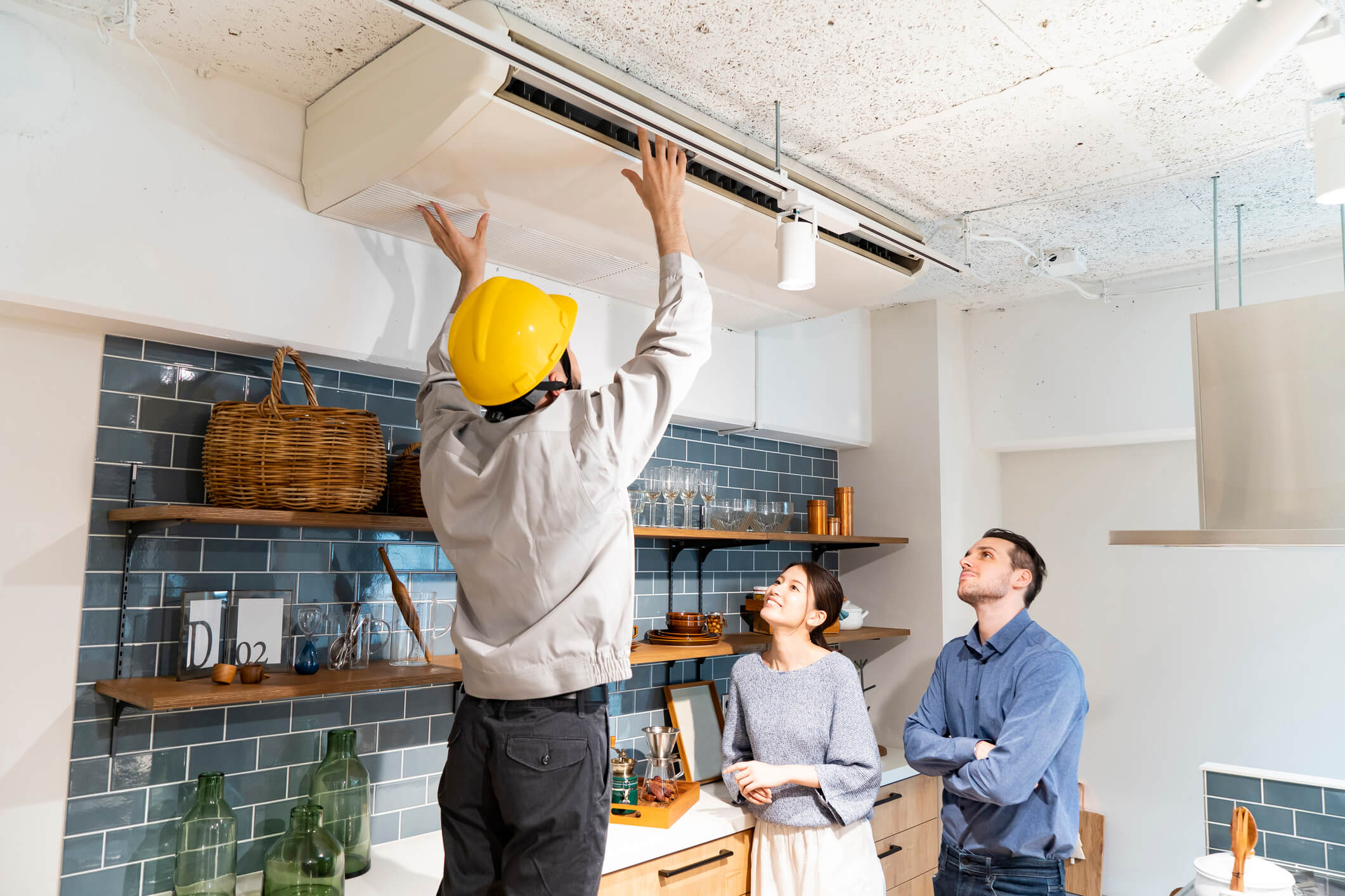 Heating and cooling professional checking air conditioner with customers watching