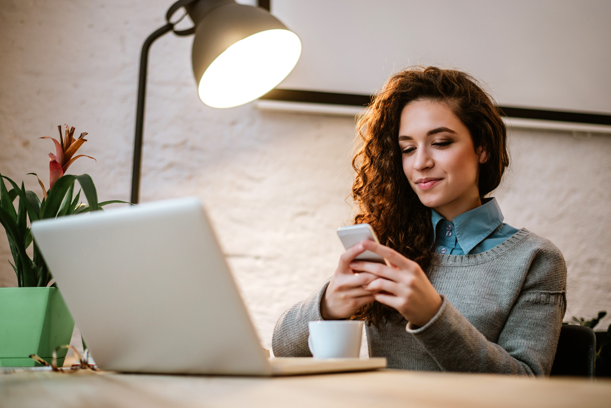 Customer service team member at her desk texting with conversational customer engagement