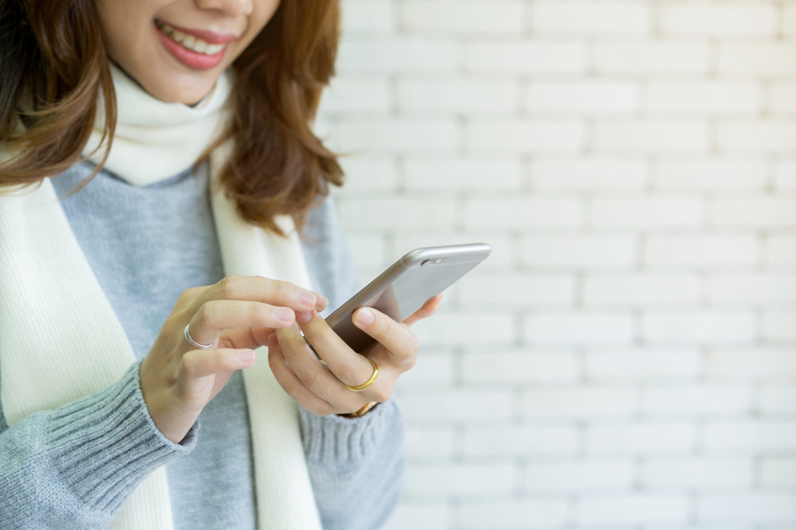 Woman in scarf texting using Conversational customer engagement