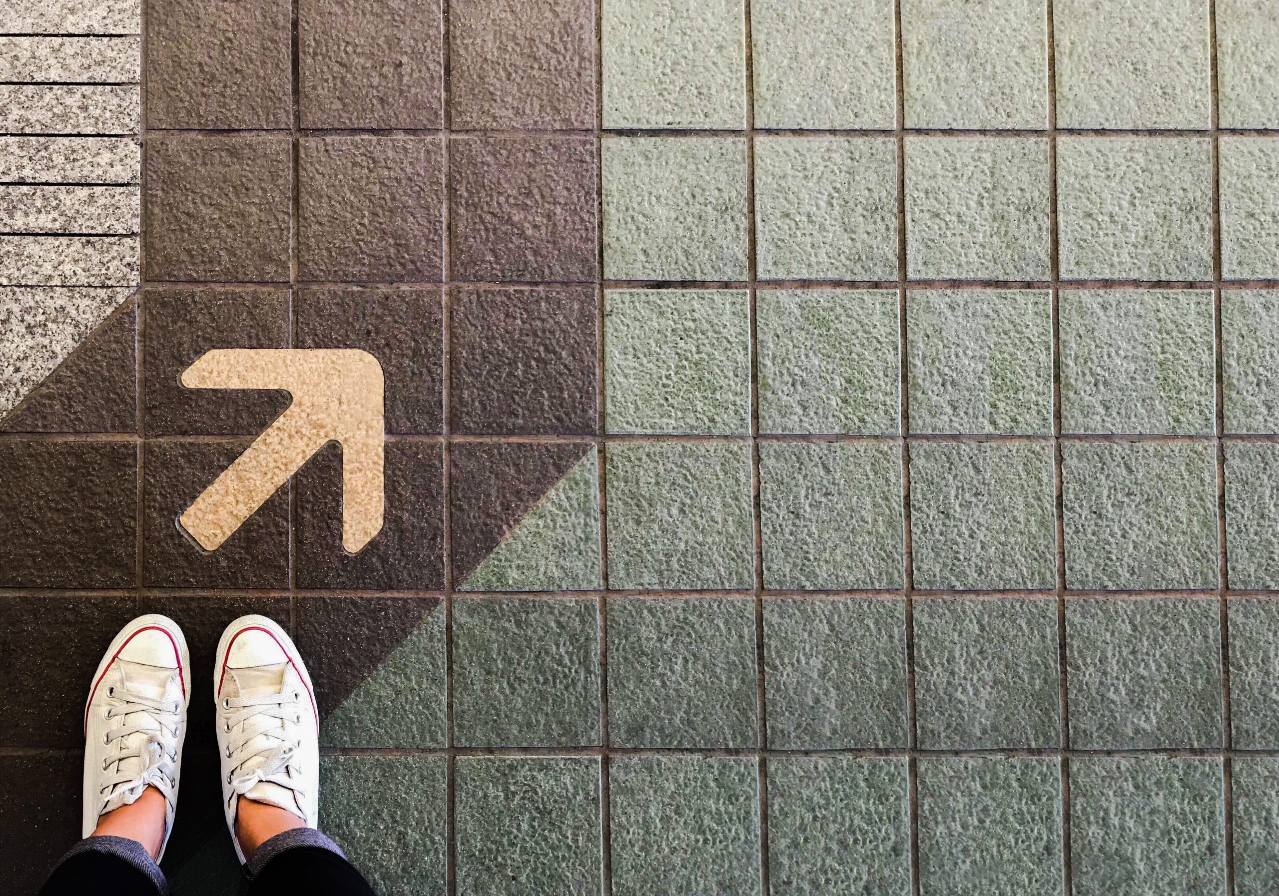 Shoes on pavement next to an arrow to signify starting with Conversational Customer Engagement