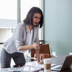 Businesswoman texting and looking at computer using conversational customer engagement