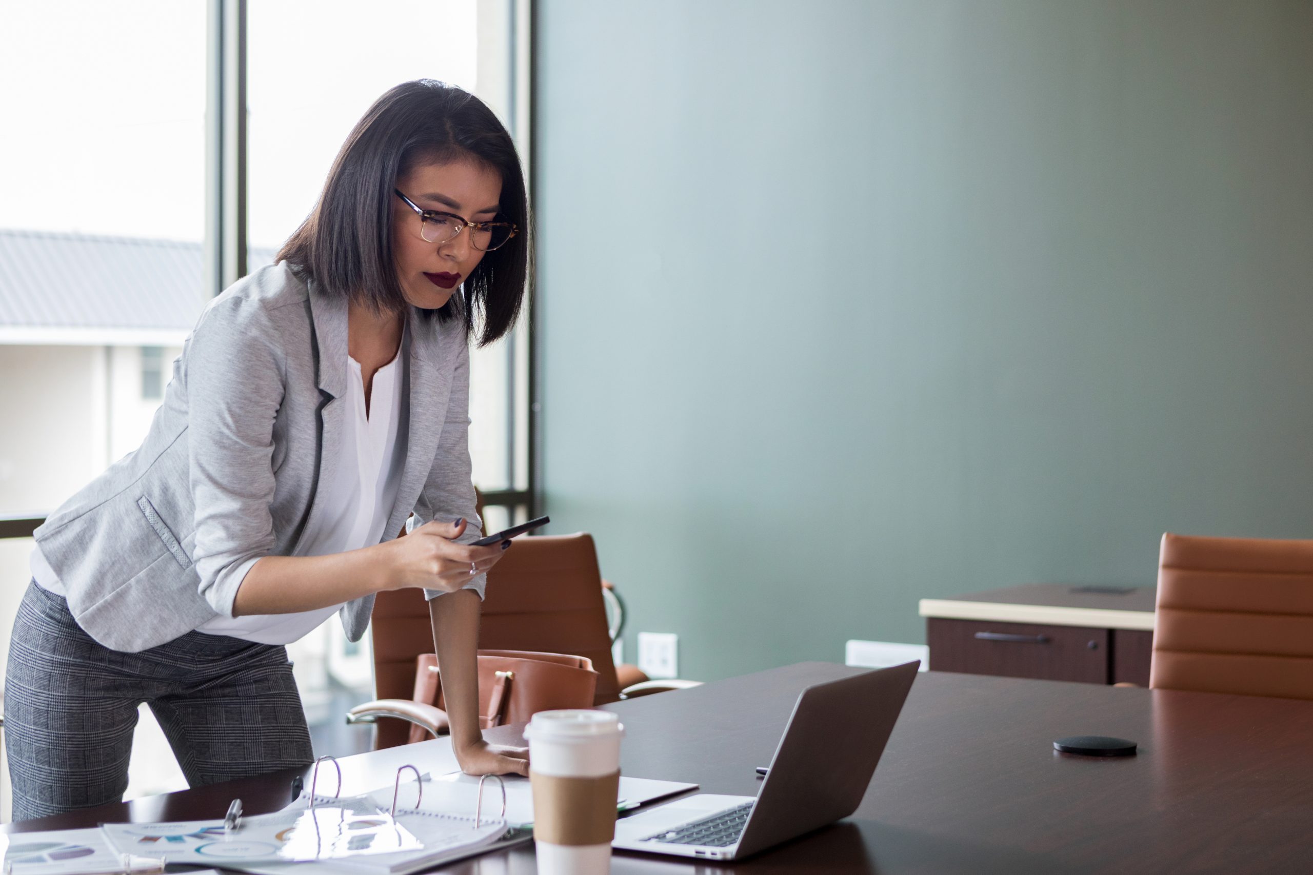 Businesswoman texting and looking at computer using conversational customer engagement 