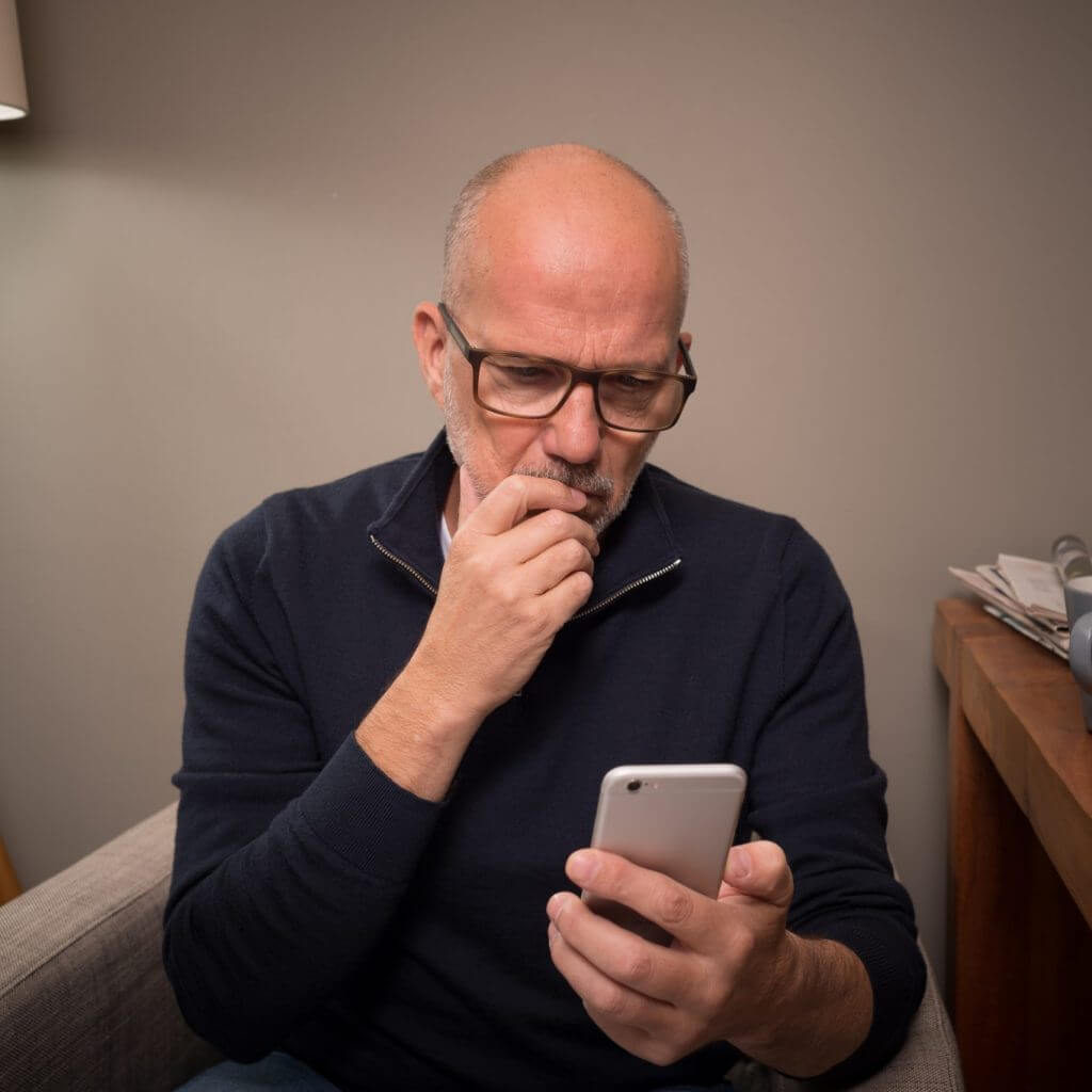 Concerned-looking man texting, meant to illustrate secure text messaging