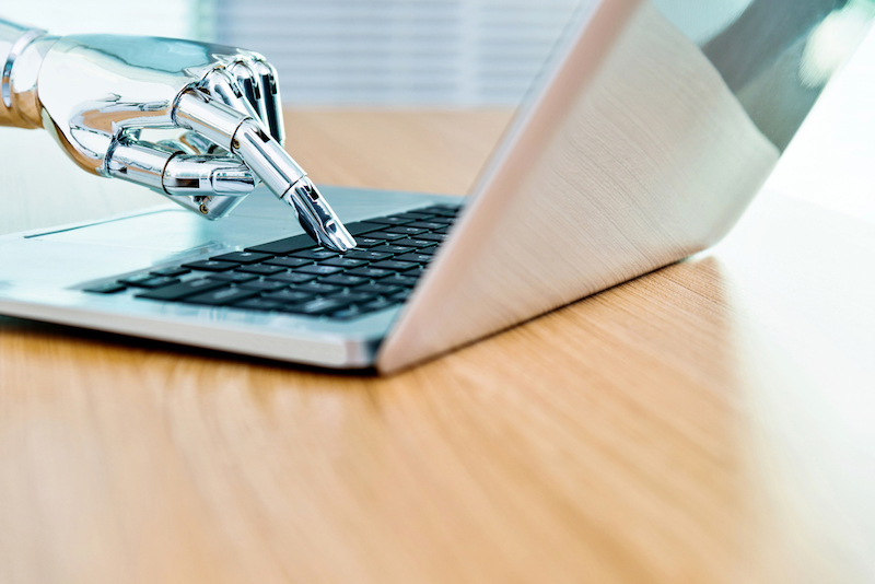 Robot hand on keyboard to signify omnichannel chatbot