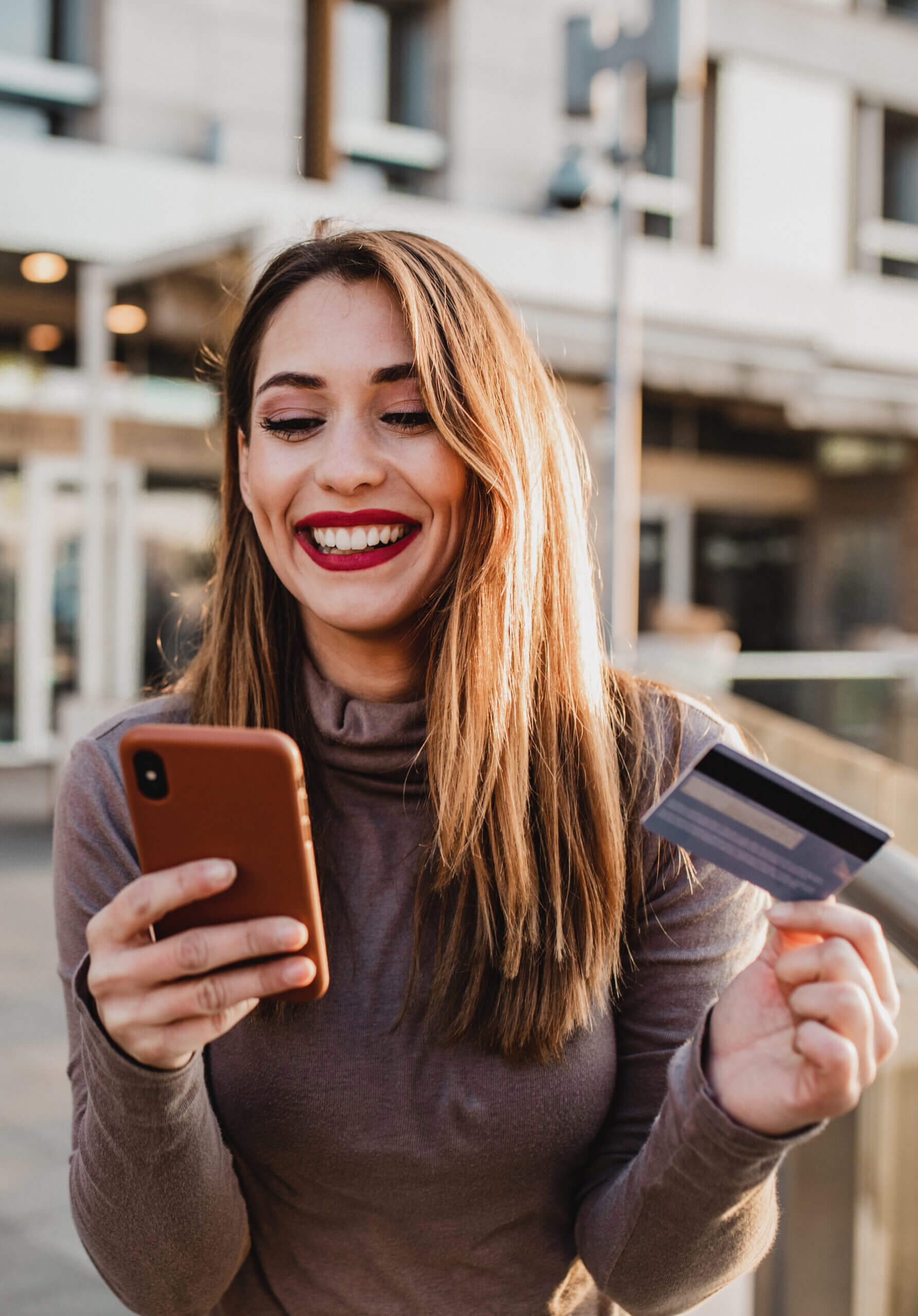 Woman outside finalizing a transaction on her mobile phone