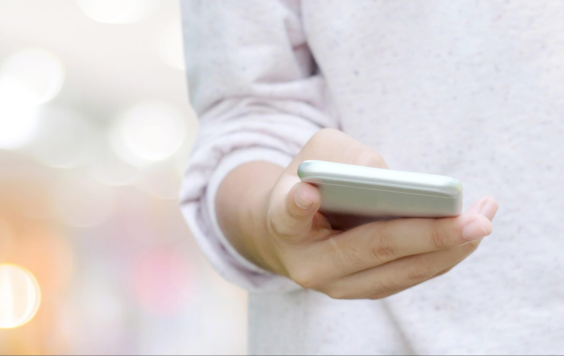 Close-up of woman holding phone to symbolize SMS integrations