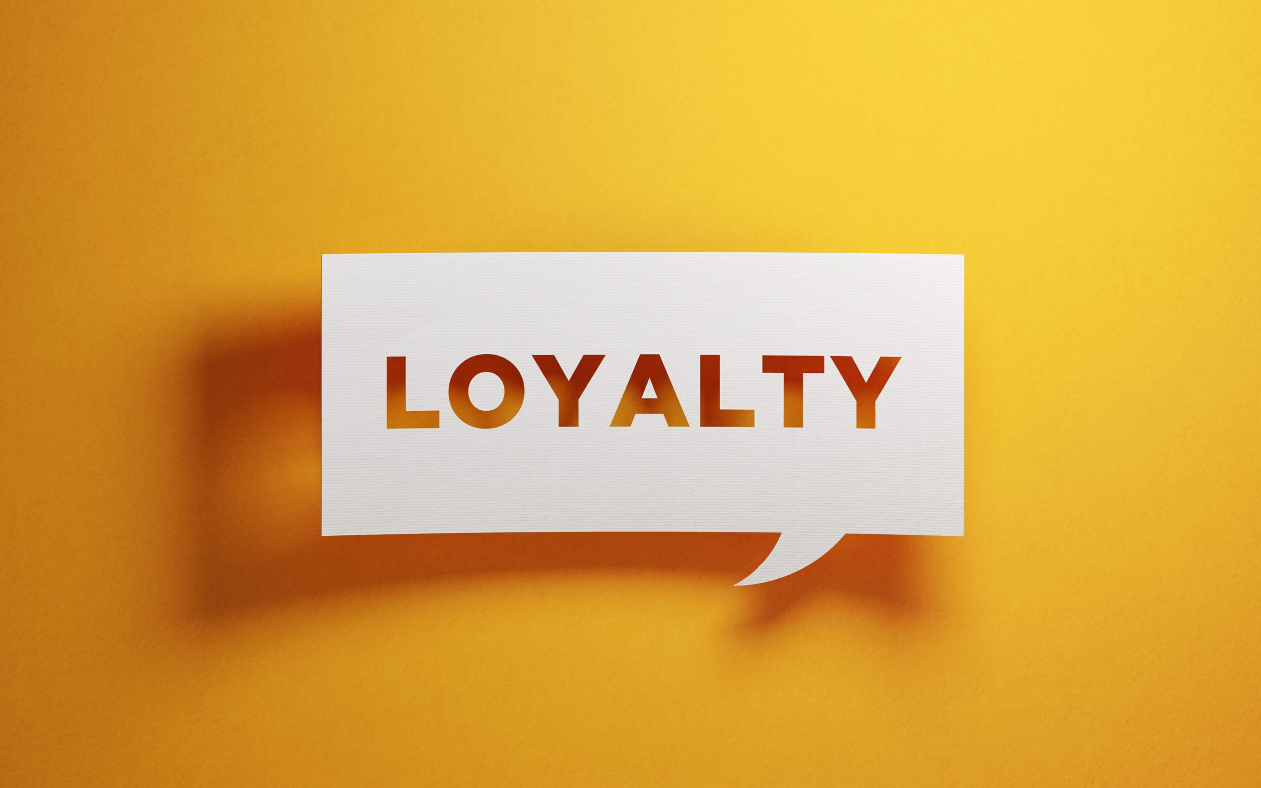 Paper sign on yellow background that says Loyalty