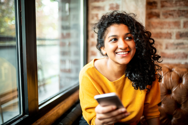 Woman using HubSpot SMS on her mobile phone
