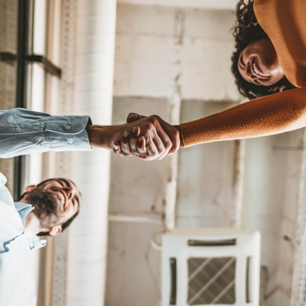 Manager and employee shaking hands after employee used business texting