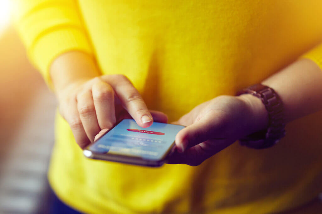 Woman texting using a 10 digit phone number, also known as a 10DLC