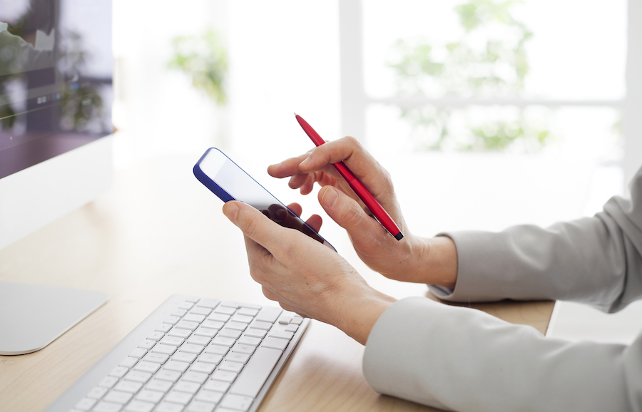 Woman using her mobile phone to schedule a text
