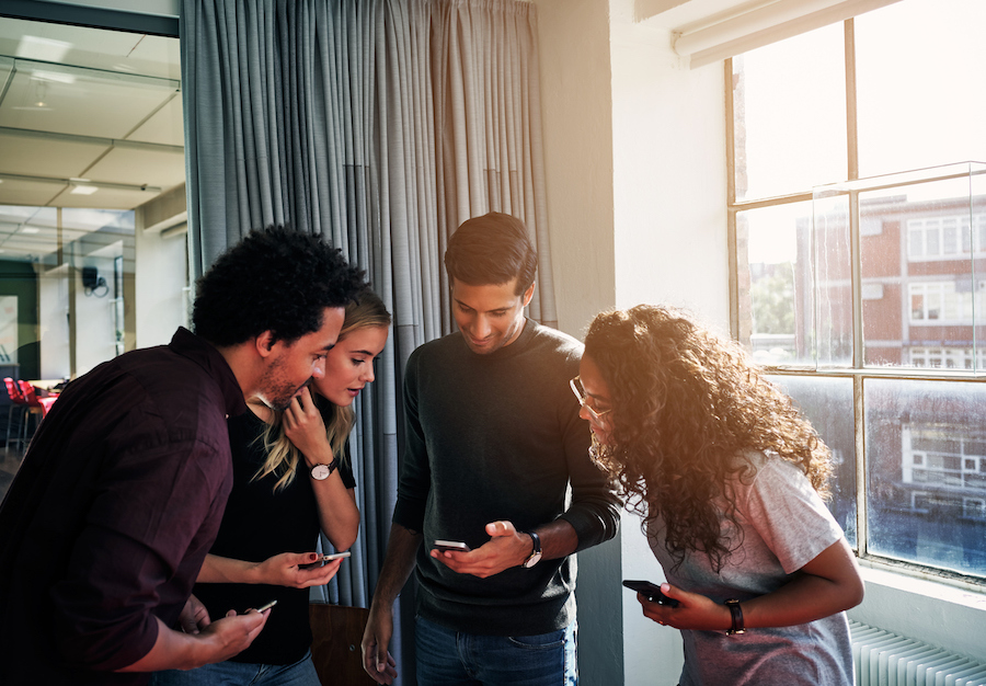 Group of young professionals looking at cellphones