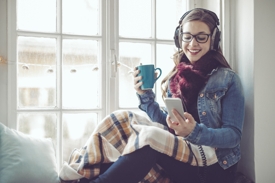 Woman texting at home by snowy window