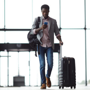 Man sending a text message at an airport.