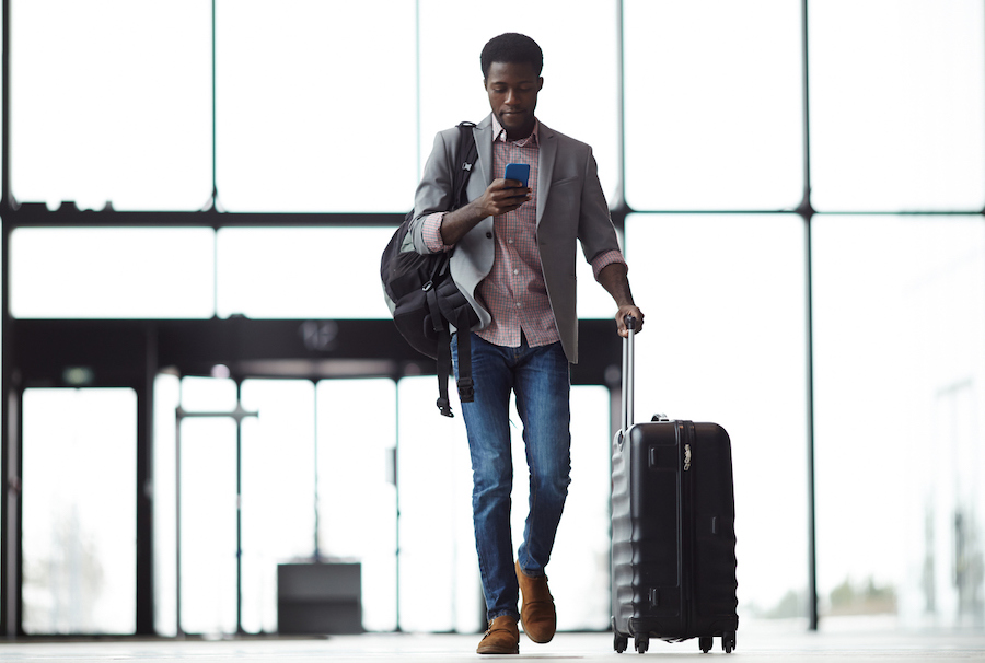 Man sending a text message at an airport.